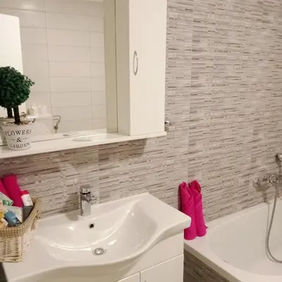 a bathroom with a white sink and a tub at Apartmaji BORŠTNER in Vransko