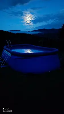 a blue tub in the dark with the moon in the background at Apartmaji BORŠTNER in Vransko