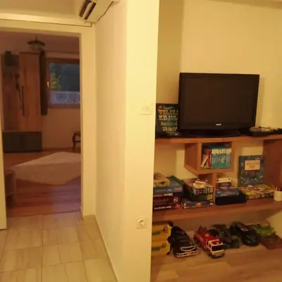 a living room with a flat screen tv on a shelf at Apartmaji BORŠTNER in Vransko