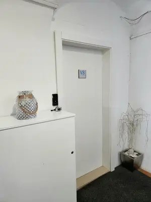 a white room with a door and a vase on a shelf at Studio Apartma V8 in Maribor