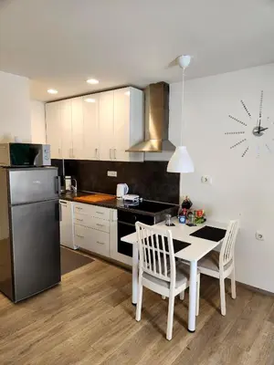 a kitchen with a table and chairs and a refrigerator at Studio Apartma V8 in Maribor