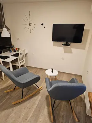 a living room with two chairs and a tv at Studio Apartma V8 in Maribor
