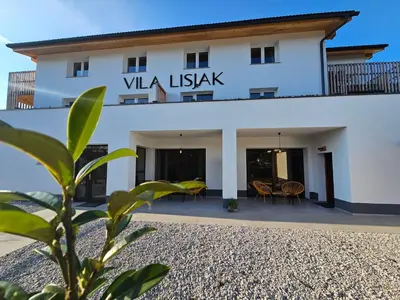 a white building with a sign that reads viva island at VILA LISJAK - Apartments in Podčetrtek