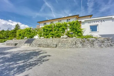 a stone retaining wall in front of a building at VILA LISJAK - Apartments in Podčetrtek