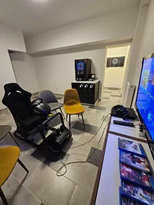 a room with a gaming room with chairs and a computer at VILA LISJAK - Apartments in Podčetrtek