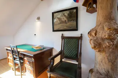 a room with a desk and a chair next to a tree at Horse Farm Holiday Pr' Kolenc in Zgornje Gorje
