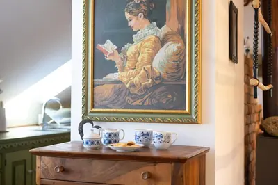 a painting of a woman reading a book on a table at Horse Farm Holiday Pr' Kolenc in Zgornje Gorje