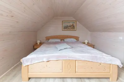 a bedroom with a wooden bed in a attic at Apartma Mikelj in Bohinj