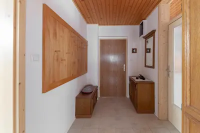 a hallway with a bathroom with a wooden door at Apartma Mikelj in Bohinj
