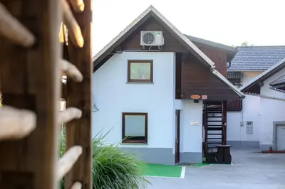a white house with a wooden roof and a staircase at Marjeta in Begunje na Gorenjskem