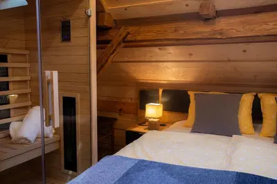 a bedroom with a bed and a wooden wall at Marjeta in Begunje na Gorenjskem