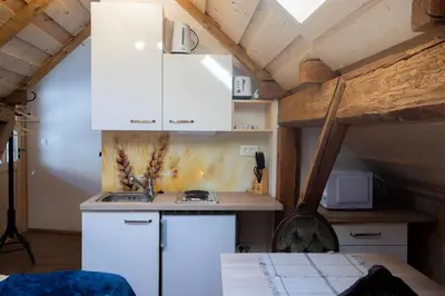 a kitchen with white cabinets and a sink in a attic at Marjeta in Begunje na Gorenjskem