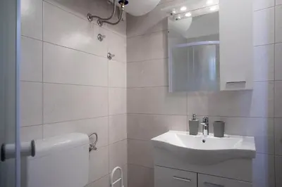 a white bathroom with a sink and a toilet at Marjeta in Begunje na Gorenjskem