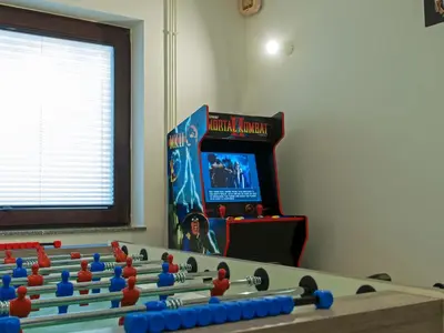 a room with a table and a video game at Holiday house Zarja - with sauna and hot tub in Bizeljsko