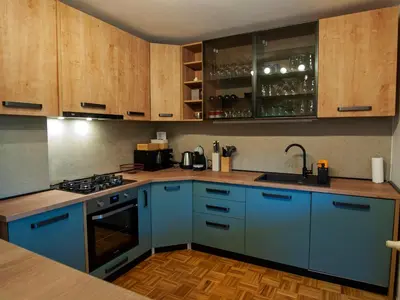 a kitchen with blue appliances and wooden cabinets at Holiday house Zarja - with sauna and hot tub in Bizeljsko