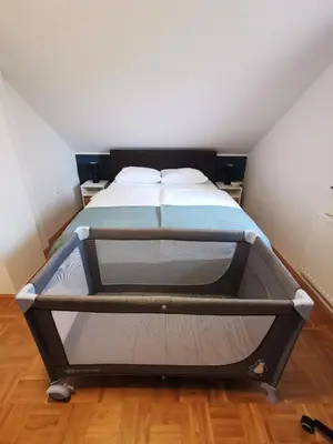a bed in a room with a bed frame at Holiday house Zarja - with sauna and hot tub in Bizeljsko