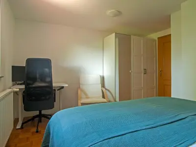 a bedroom with a bed and a desk and a chair at Holiday house Zarja - with sauna and hot tub in Bizeljsko