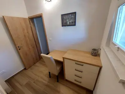 a small room with a wooden desk and a chair at Prenočišča v Kraški Hiši in Komen