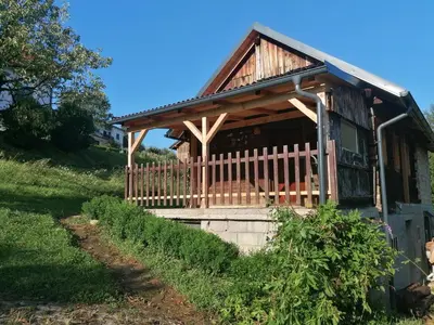 a log cabin with a porch and a fence at Hiška ob gozdu in Polzela