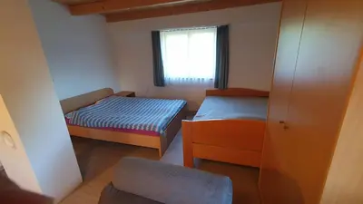 a small room with two beds and a window at Hiška ob gozdu in Polzela