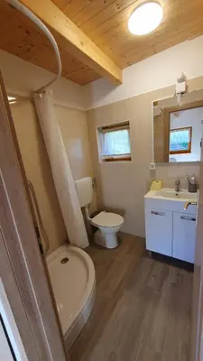 a small bathroom with a toilet and a sink at Hiška ob gozdu in Polzela