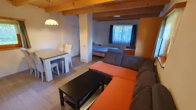 a living room with a couch and a table at Hiška ob gozdu in Polzela