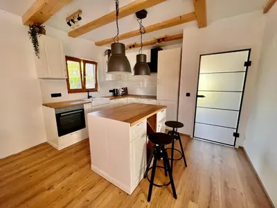 a kitchen with white cabinets and a wooden floor at Vila Milan in Bled