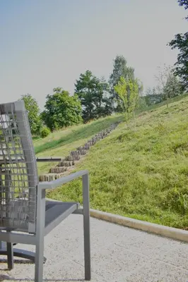a chair sitting on the ground next to a field at Studio apartment Velis in Radovljica
