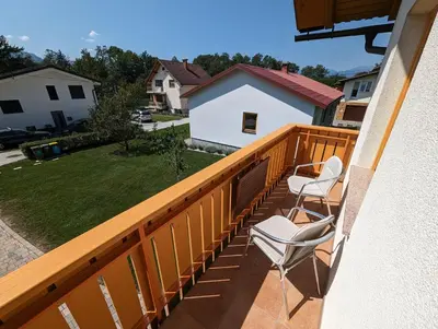 a balcony with two chairs and a yard at Studio apartment Velis in Radovljica