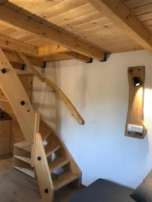 a staircase in a room with a wooden ceiling at Apartma Povlč in Poljane nad Škofjo Loko