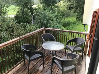 a table and chairs sitting on a deck at Apartma Povlč in Poljane nad Škofjo Loko