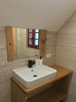 a bathroom with a white sink and a mirror at Apartma Povlč in Poljane nad Škofjo Loko