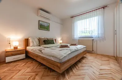 a bedroom with a large bed and a window at Apartment Vita in Bled