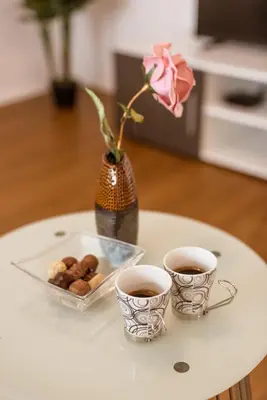two cups of coffee and a tray of donuts on a table at Apartma Sofija, Moravski Dvori in Moravske Toplice