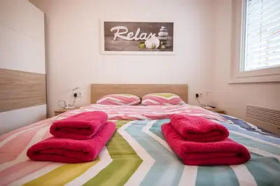 a bedroom with pink blankets on a bed at Apartma Sofija, Moravski Dvori in Moravske Toplice