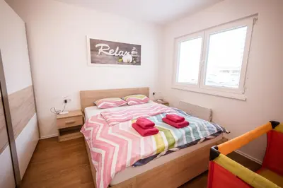 a bedroom with a bed with red towels on it at Apartma Sofija, Moravski Dvori in Moravske Toplice