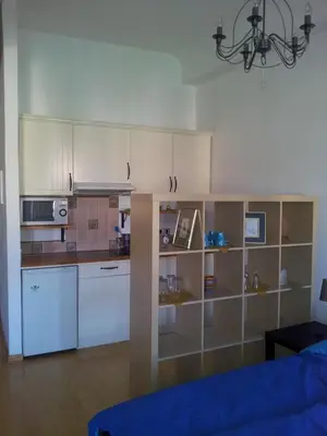 a kitchen with white cabinets and a chandelier at Studio Ian 1 in Ljubljana