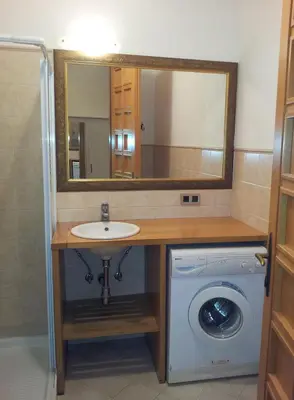 a bathroom with a sink and a washing machine at Studio Ian 1 in Ljubljana