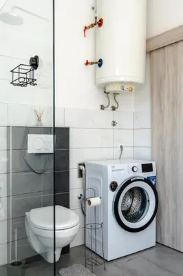 a bathroom with a washing machine and a toilet at Apartment Ivana Krško in Krško