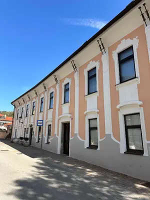 a large orange and white building with windows at Apartment Ivana Krško in Krško