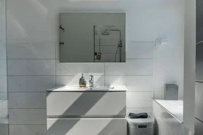a white bathroom with a sink and a mirror at Apartment Ivana Krško in Krško