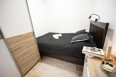 a small bedroom with a black bed and a mirror at Apartment MaRI&BoR-No Stairs, Easy Access, Garage optional in Maribor