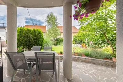 a table and chairs on a patio with a garden at Vila ART in Ljubljana