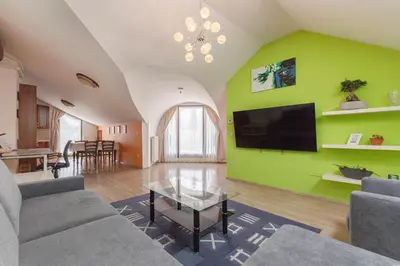 a living room with a green wall with a flat screen tv at Vila ART in Ljubljana