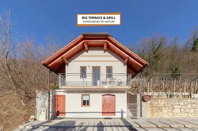 a small white house with a red roof at Zidanica med Trtami in Dvor