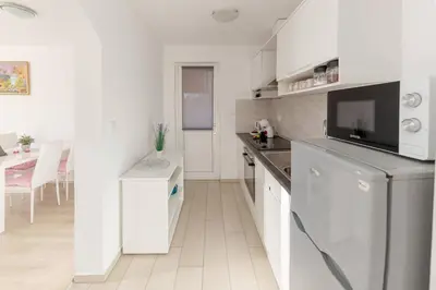 a kitchen with white cabinets and a counter top at Zidanica med Trtami in Dvor