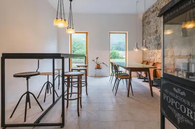 a restaurant with tables and stools in a room at 2nd Station Hostel in Bled