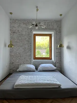 a bedroom with a large bed with a window at 2nd Station Hostel in Bled