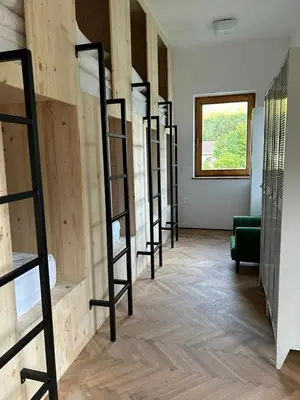 a row of bunk beds in a room with a window at 2nd Station Hostel in Bled