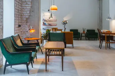 a room with chairs and tables in a room with a table at 2nd Station Hostel in Bled